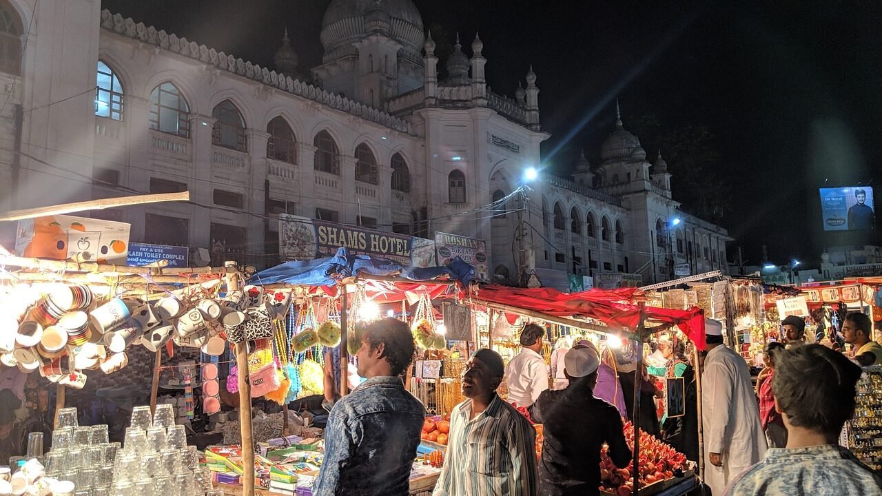 A busy Indian market street lined with vendor stalls, illustrating how aggregator listings compete for attention the way market stalls compete for footfall