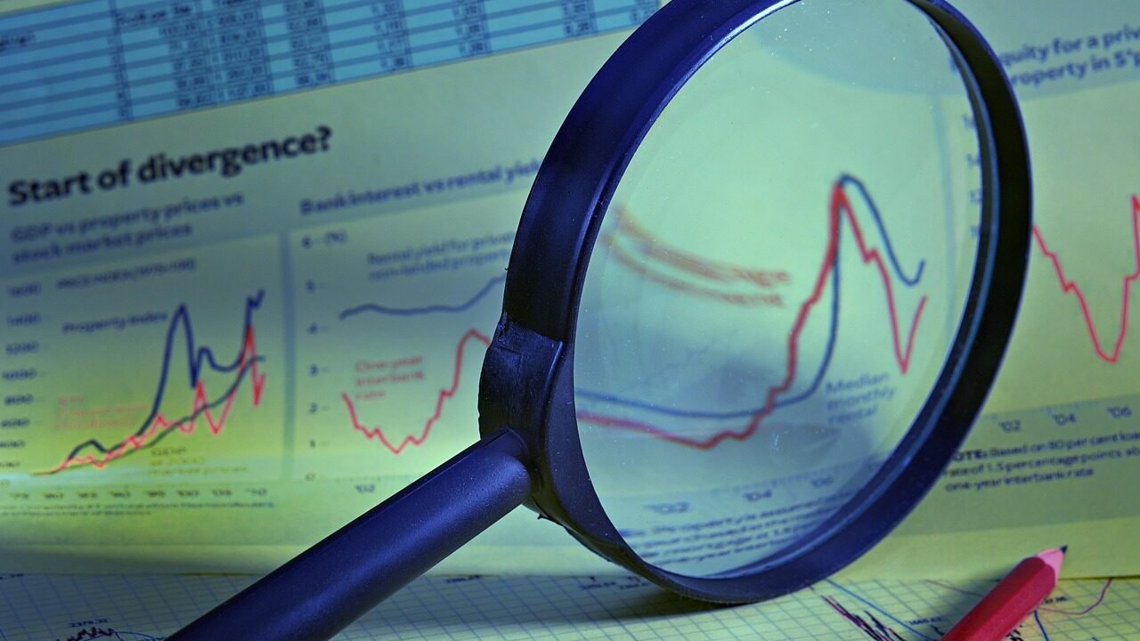Magnifying glass over charts and tables, representing a structured competitor analysis process