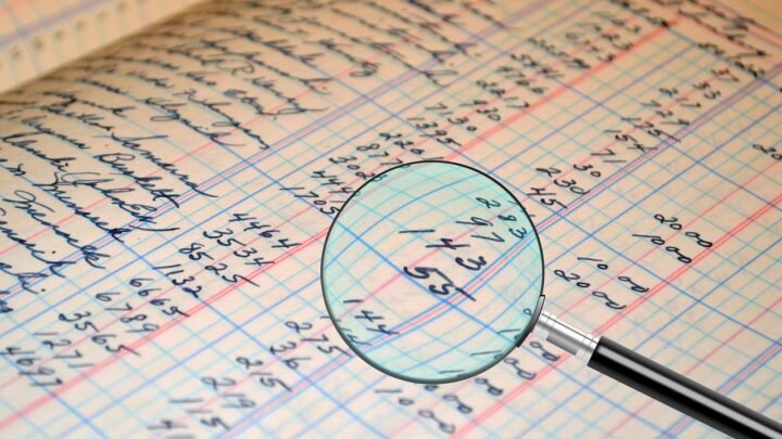 A magnifying glass over financial and accounting documents, representing close review of compliance records under a data protection law