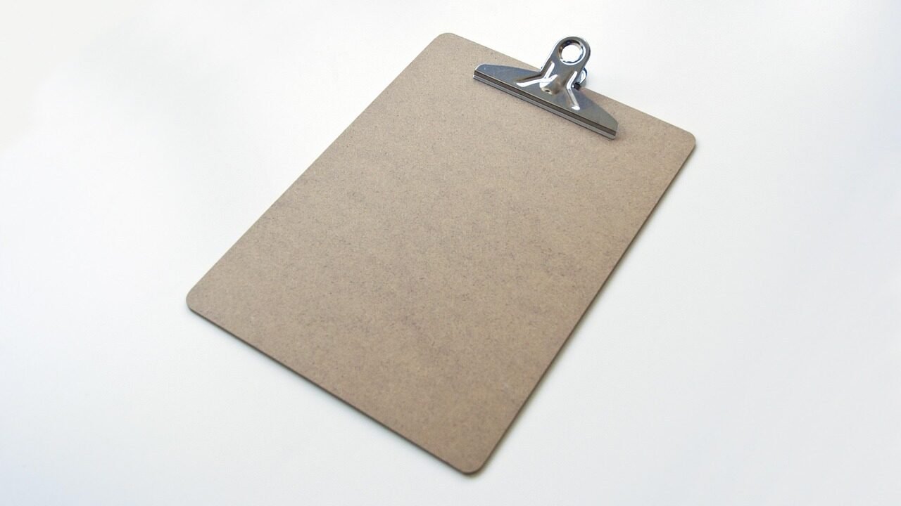 A blank clipboard checklist on an office desk representing the short list of metrics a founder dashboard should track