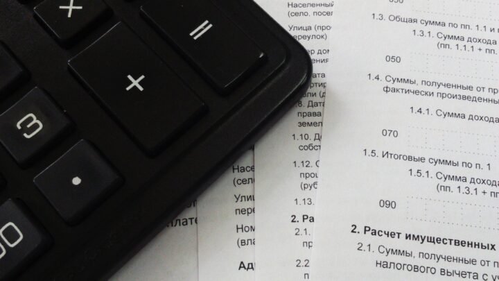 A calculator sitting on tax and finance paperwork, representing GST calculation on a digital marketing invoice