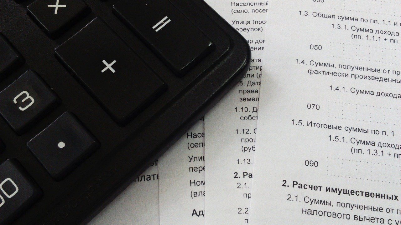 A calculator sitting on tax and finance paperwork, representing GST calculation on a digital marketing invoice