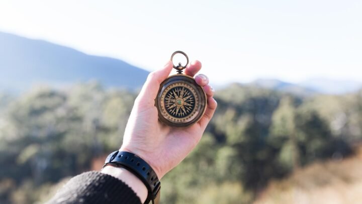 A hand holding a compass outdoors, symbolizing the search for direction before a startup finds product-market fit