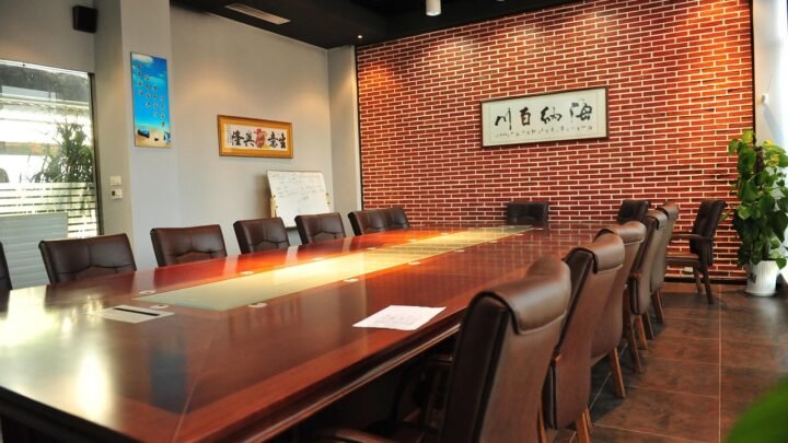 Two business people at a meeting room table discussing a marketing agency contract