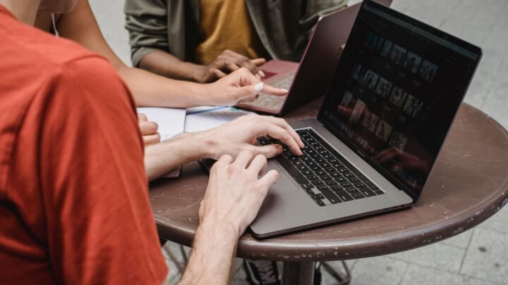 Person reading Reddit and Quora discussion threads on a laptop while doing keyword research