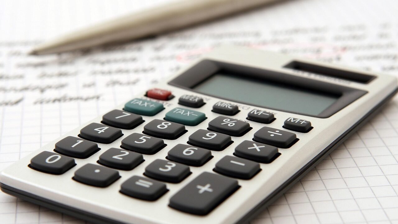 Calculator and financial documents on a desk representing SEO agency costs and hidden fees